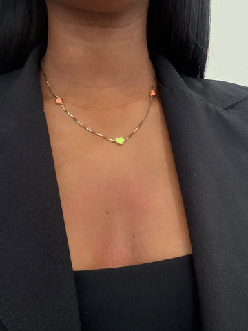 Close-up of a woman wearing a gold heart pendant necklace