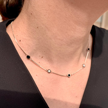 Delicate gold necklace with black and white charms