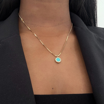 Gold-tone box chain necklace with a circular turquoise and zirconia pendant