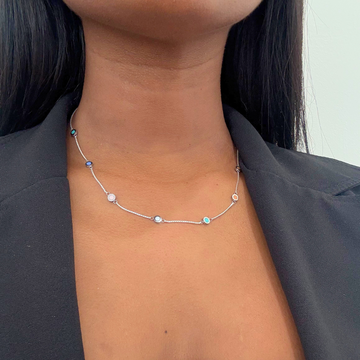 Women's multi-color enamel necklace styled with a black outfit.