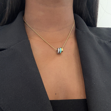 Elegant triple ring pendant necklace in gold-tone with white enamel and pave accents