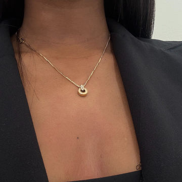 Close-up of a beige cord Nereida necklace, worn by a woman