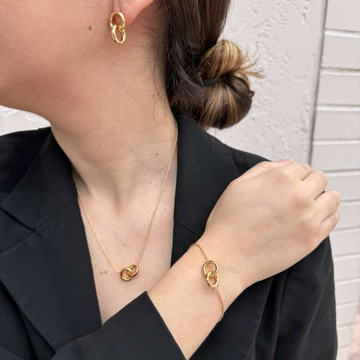 Woman wearing matching gold interlocking ring jewelry set 
