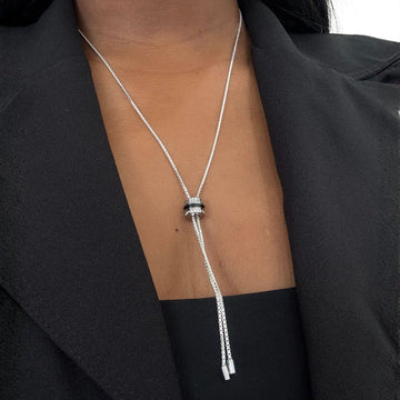 Adjustable silver lariat necklace featuring a white and pave crystal sliding pendant.