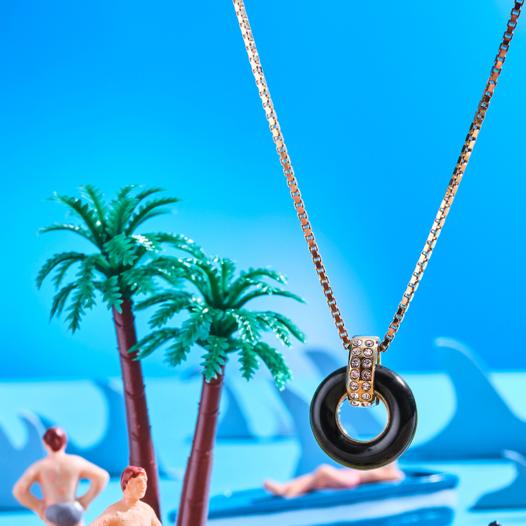 A Jason Hyde Lifesaver necklace featuring a black circular pendant