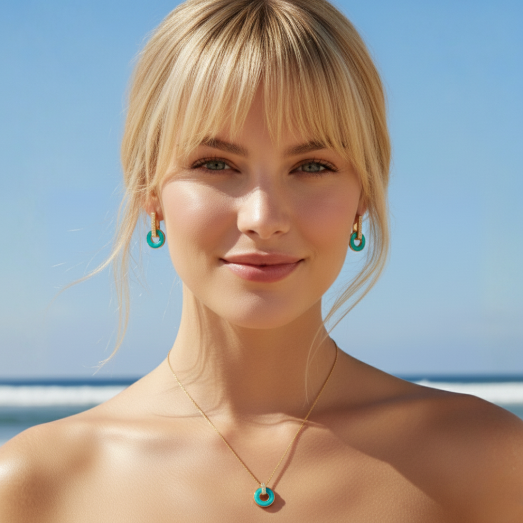 Gold turquoise hoop earring and pendant necklace set worn at the beach.