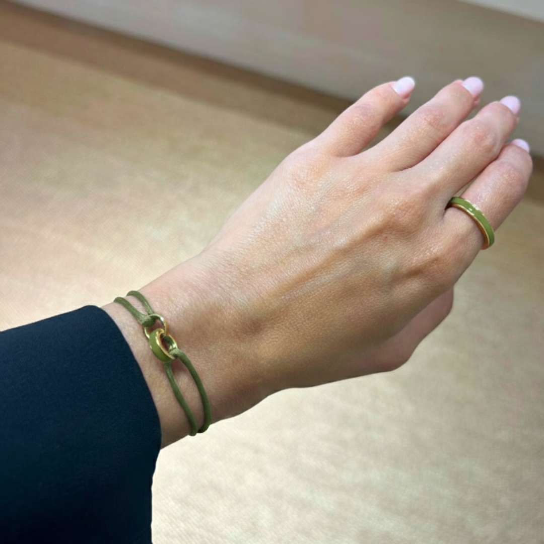 Olive green cord bracelet with gold clasp on a woman's hand