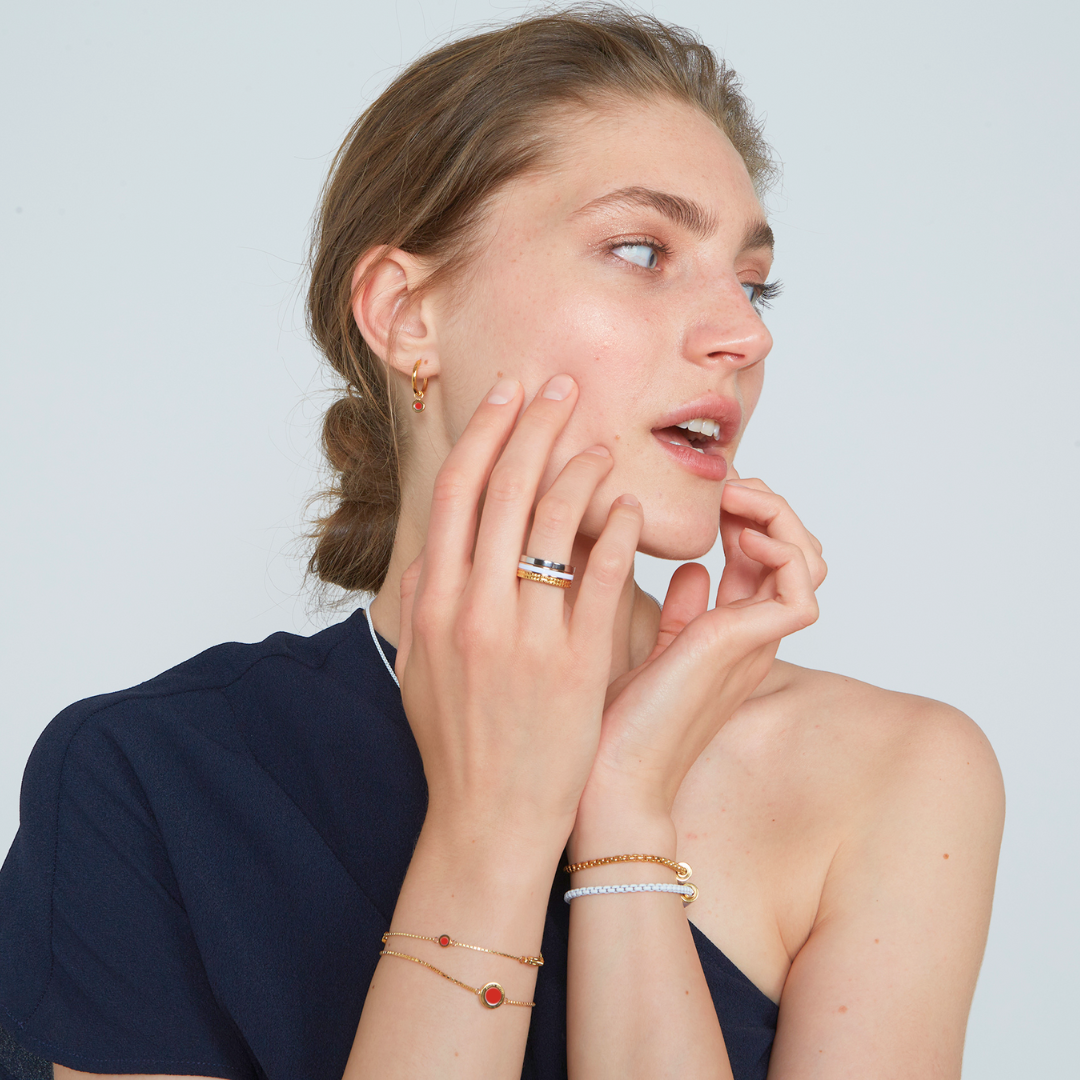 Model wearing Jason Hyde jewelry: new wave red chip bracelet, white bracelet, gold rings.