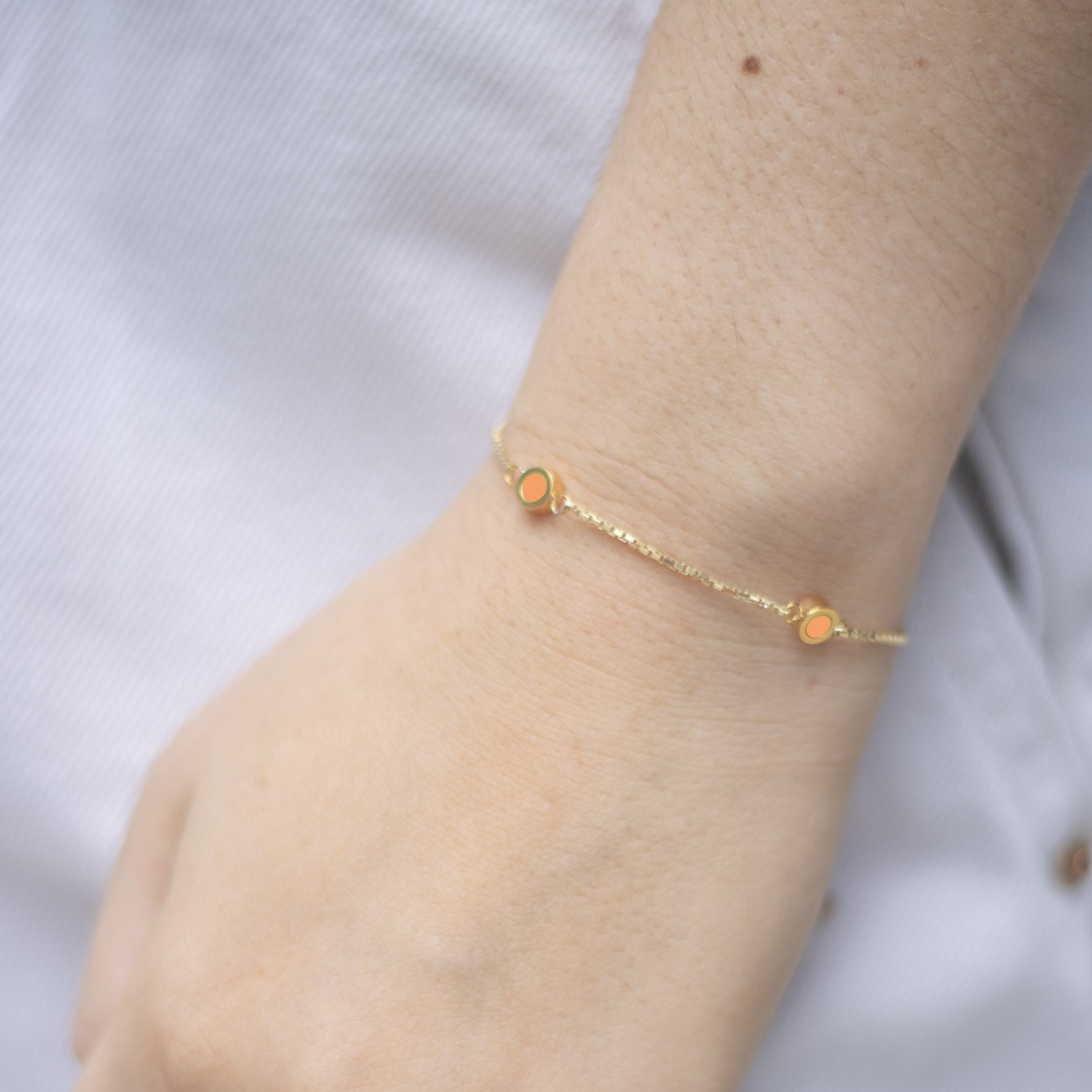 Close-up of Jason Hyde 'New Wave Apricot Crush 3 chip bracelet' on a wrist