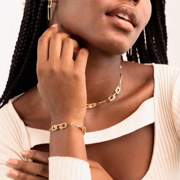 Stylish woman wearing a trendy Jason Hyde gold-tone link jewelry set.