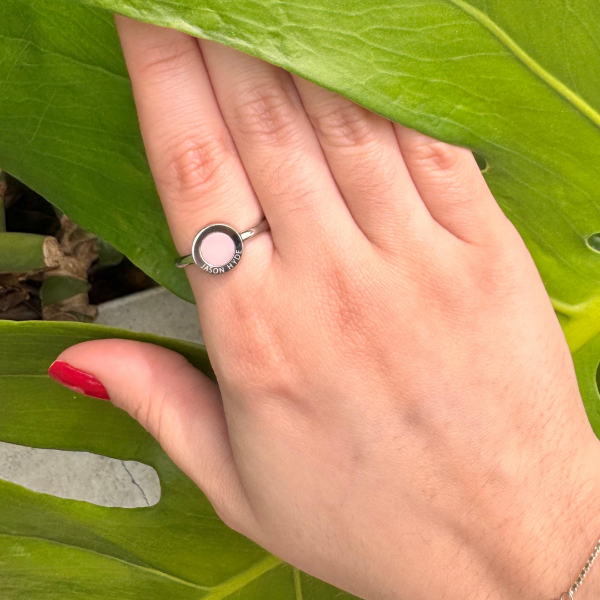 Jason Hyde silver-tone ring with pink enamel center on a hand.