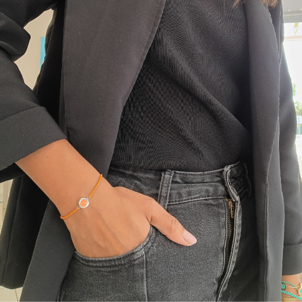 Sleek orange chain bracelet with circular charm by Jason Hyde