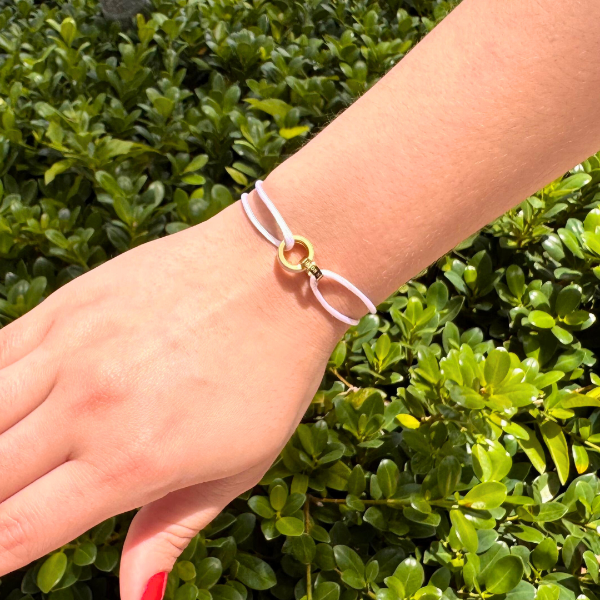 Jason Hyde white cord bracelet with gold-tone intertwined knot detail.