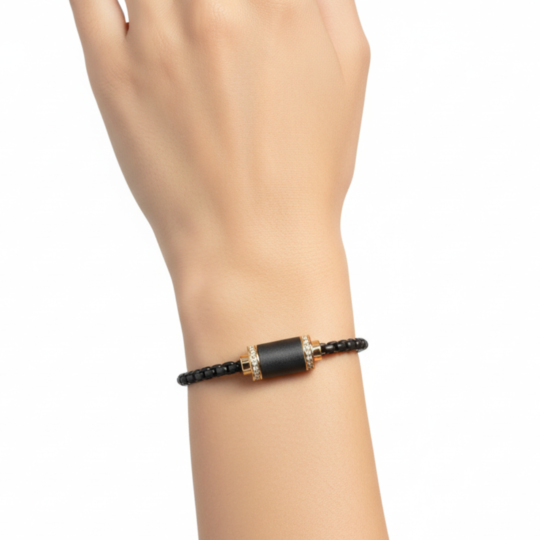 Black bead bracelet with zirconia-encrusted gold cylinder on a wrist