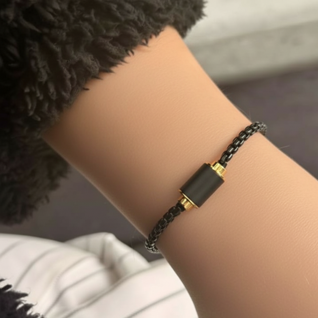 Black curb chain bracelet with matte black cylinder on a wrist