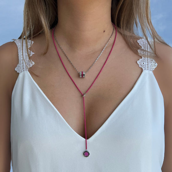 Close-up of a woman's décolletage showcasing layered Jason Hyde necklaces.