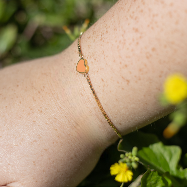 Gold bracelet featuring an apricot crush eco-friendly heart charm by Jason Hyde