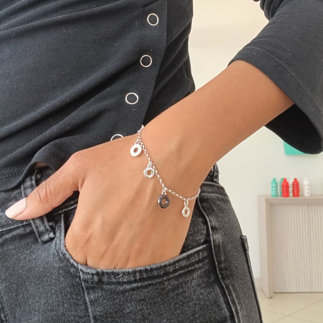 A close-up shot of a person wearing a Jason Hyde Acquarello Hanging Round Bracelet