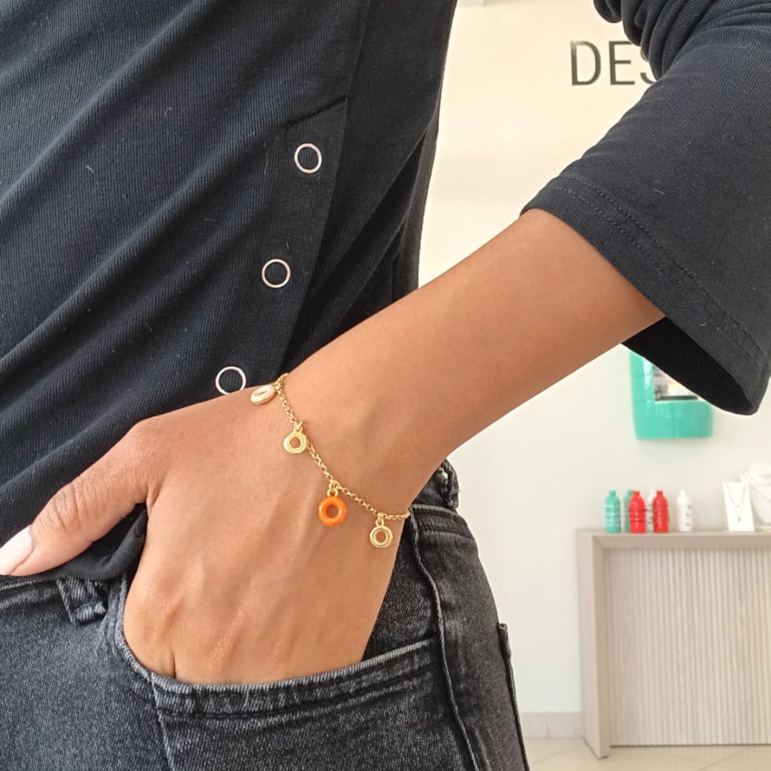 A close-up shot of a person wearing a Jason Hyde Acquarello Hanging Round Bracelet