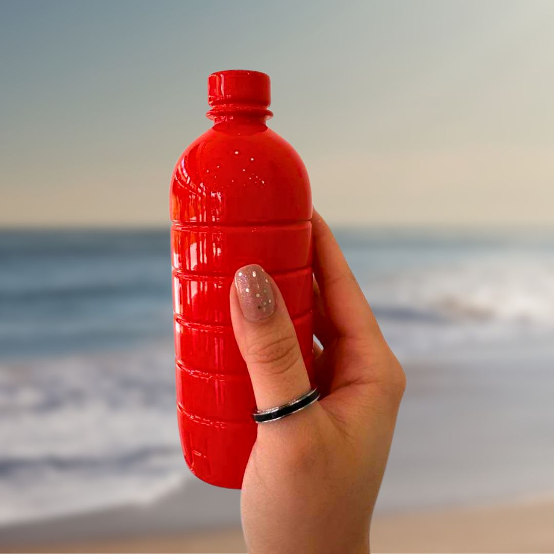A hand with a Wewa single black chip ring, holding a red water bottle 