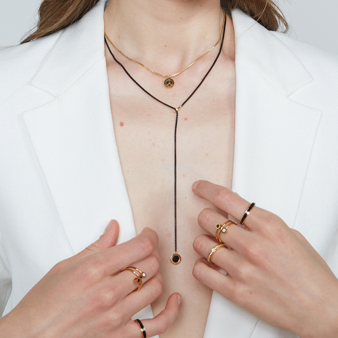 Woman wearing Jason Hyde gold and black Y-necklace and gold rings