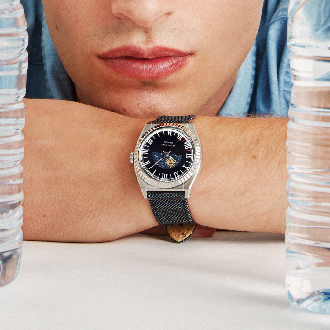 A close-up of a model, showcasing a silver-toned watch on their wrist