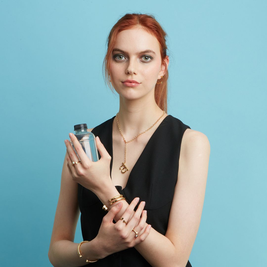 A woman with red hair wearing a black dress and gold jewelry