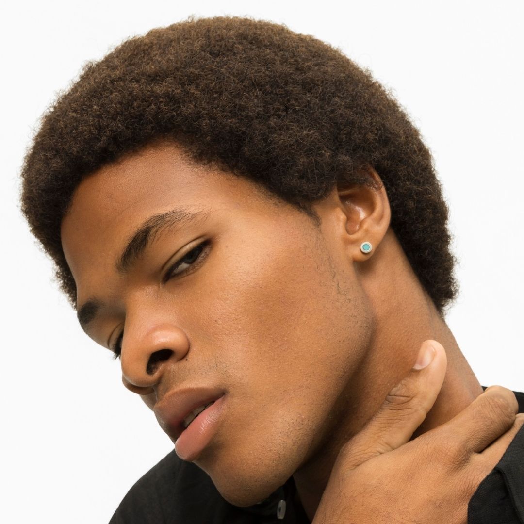 Young man with an afro and a turquoise stud earring.