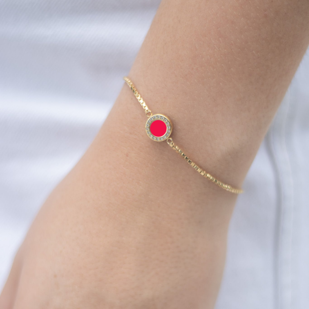 Delicate gold bracelet with red enamel charm and zirconia halo 