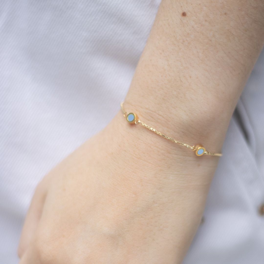 Gold chain bracelet with powder blue chips on wrist