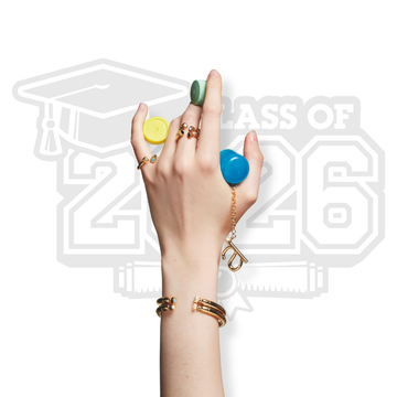 Hand modeling Jason Hyde graduation jewelry charms with Class of 2026 background