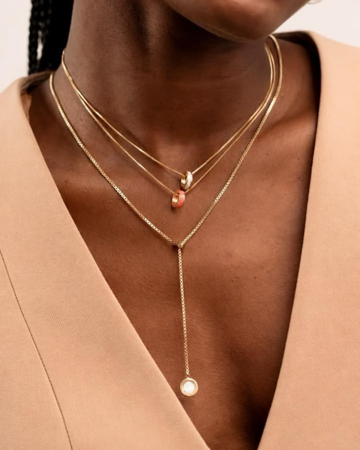 Woman wearing layered gold chain necklaces by Jason Hyde.