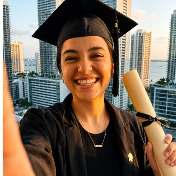 Graduate wearing Jason Hyde jewelry holding diploma during Class of 2026 celebration in Miami 
