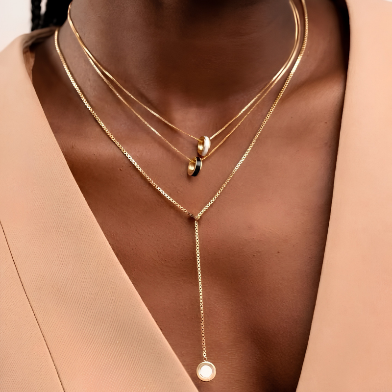 Gold layered necklace set with round enamel pendants by Jason Hyde.