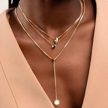Gold layered necklace set with round enamel pendants by Jason Hyde.
