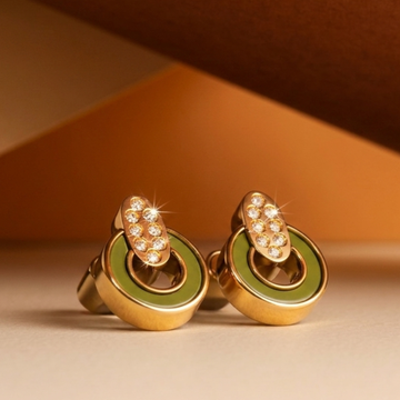 A pair of round gold cufflinks with olive green enamel rings and a zirconia