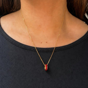 Gold necklace with a red enamel pendant by Jason Hyde.
