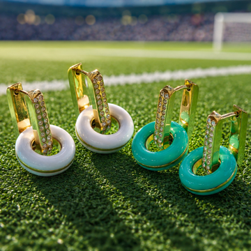 Two pairs of Jason Hyde sustainable gold huggie hoop earrings featuring pavé crystals on the front bar