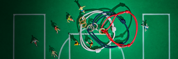 Three Jason Hyde sustainable cord bracelets arranged on a miniature green soccer field with tiny player figurines