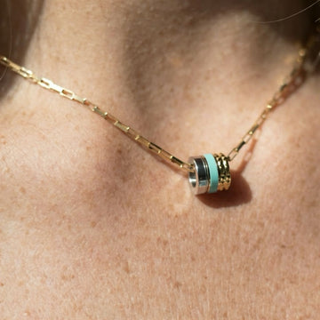 Close-up of a woman wearing a recycled ocean plastic pendant necklace.