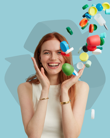 Happy red-haired woman holding and dropping various colored reusable plastic bottles