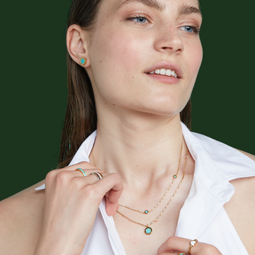 Woman wearing gold and turquoise jewelry.