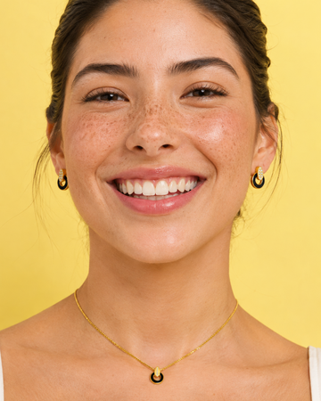 Woman against a yellow backdrop wearing a Jason Hyde nereida set