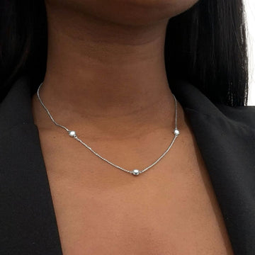 Jason Hyde minimalist silver necklace with three white recycled ocean plastic accents.