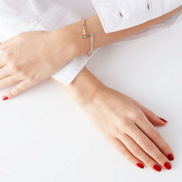 Jason Hyde silver cuff bracelet with turquoise and white recycled plastic accents on a woman's wrist.