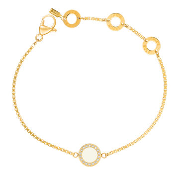 Gold chain bracelet with a white circular charm by Jason Hyde.