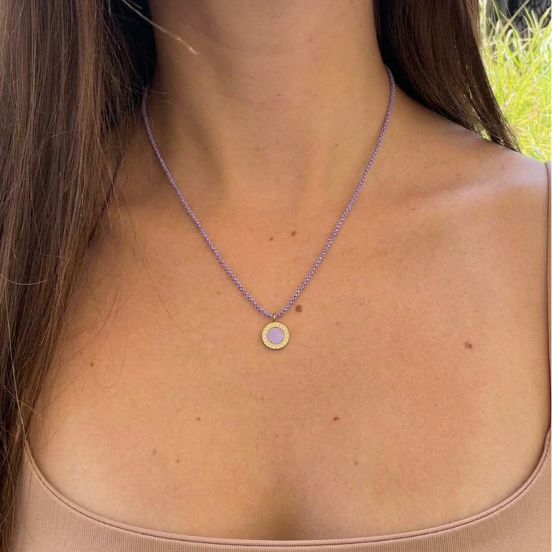 Close-up of a person wearing a sustainable lavender necklace 