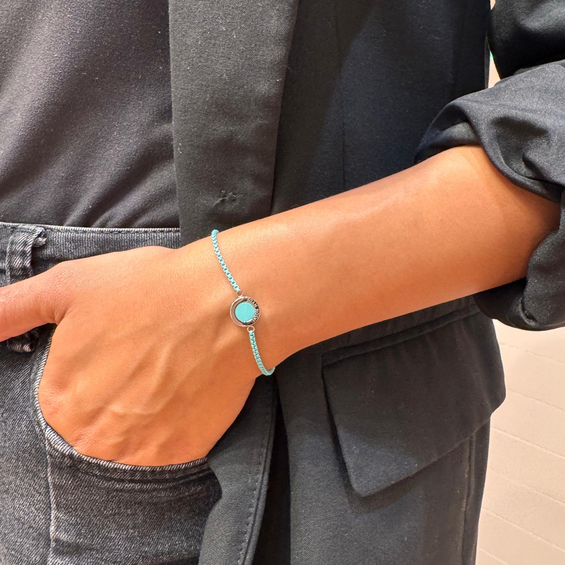 Turquoise and gold bracelet on a person's wrist.