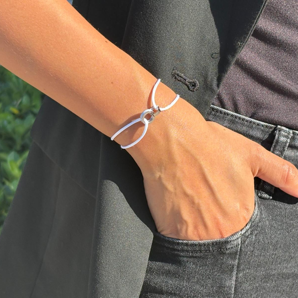White cord bracelet with silver loops on a wrist