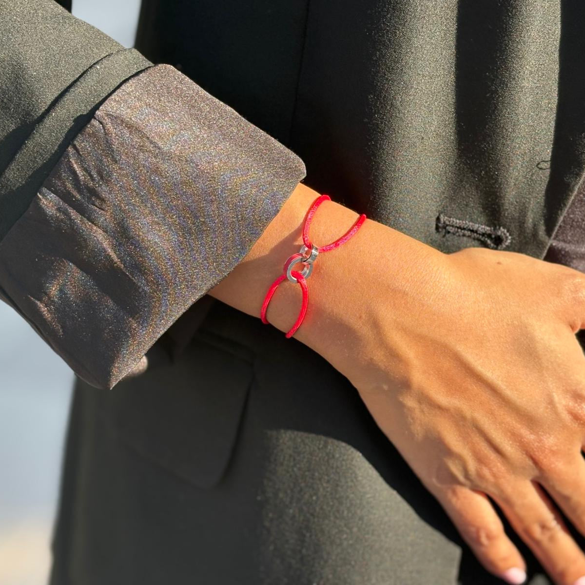 Minimalist red cord bracelet featuring interconnected silver circle details